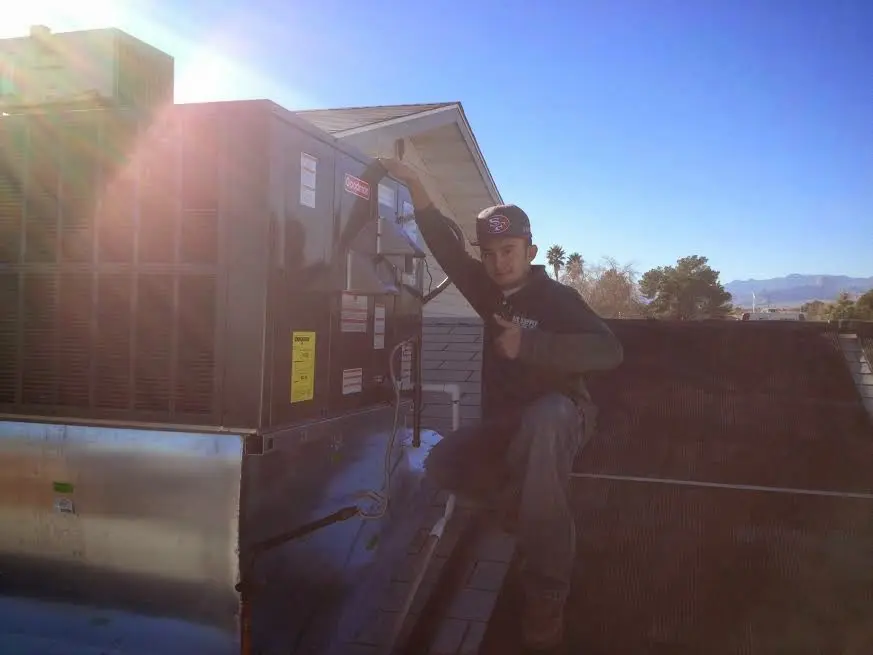 HVAC technician performing AC Tune-Up on a rooftop unit in San Dimas